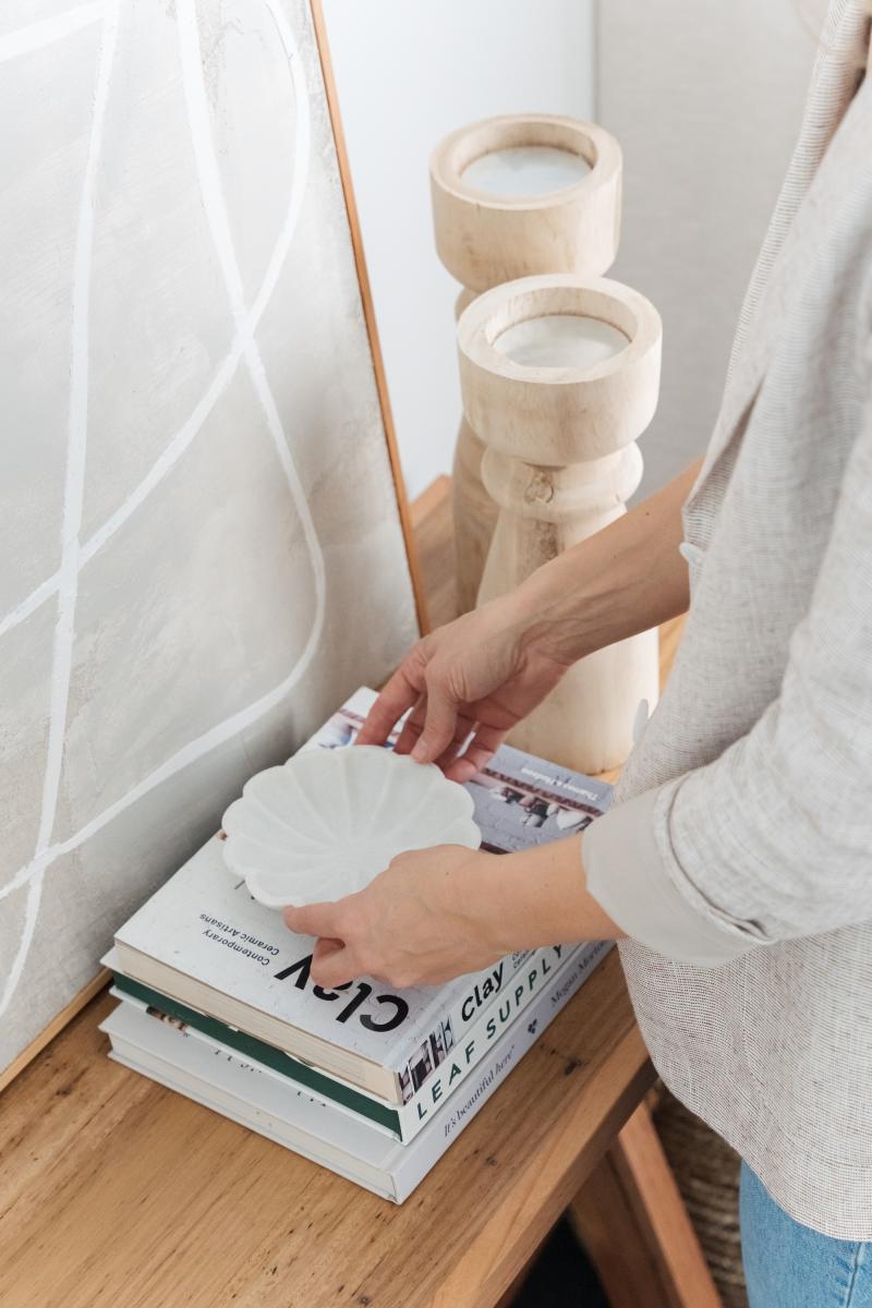 Place a decorative object on a stack of books 